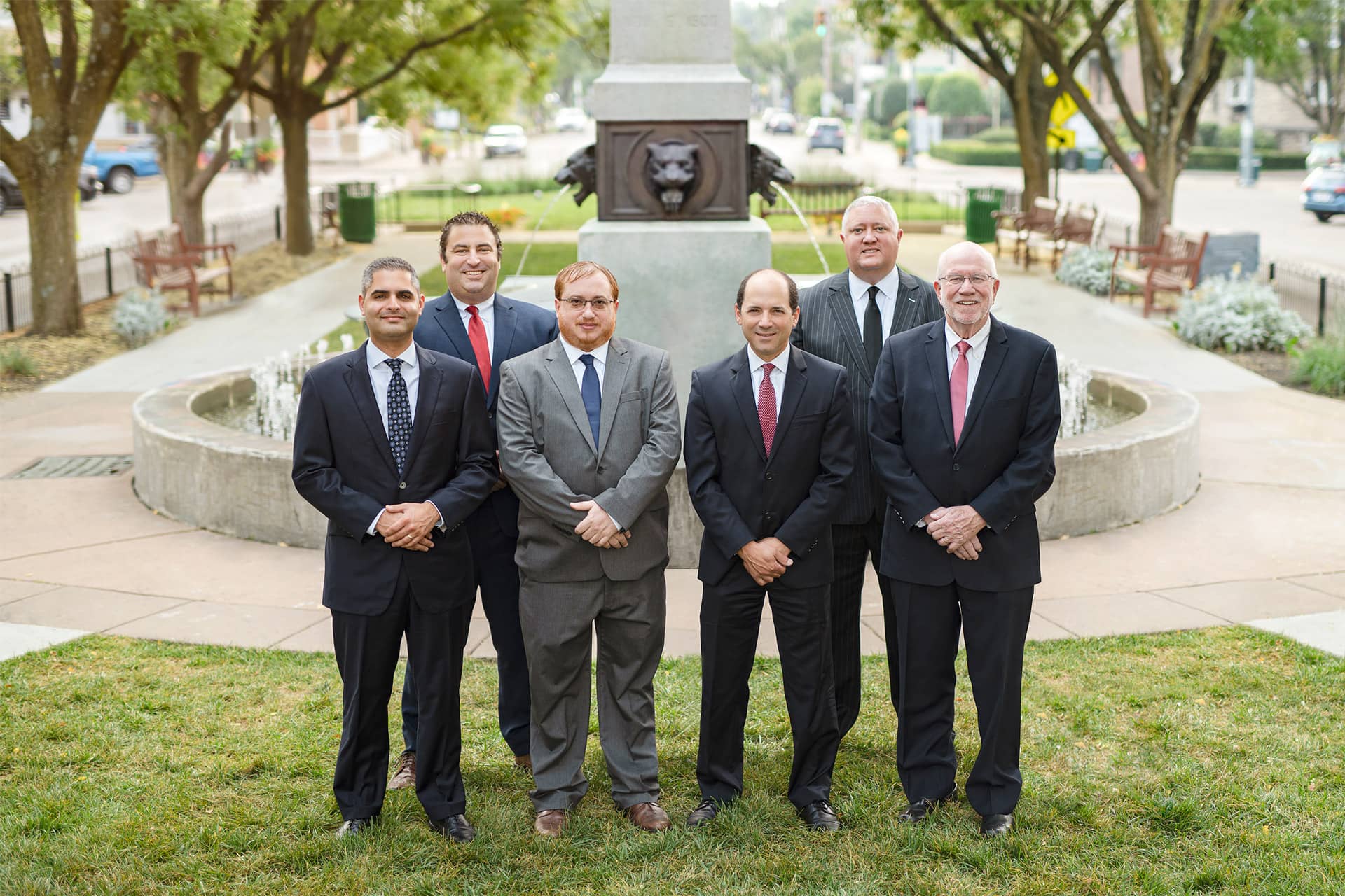 Minnillo Law Group standing in front of fountain in park on sunny day